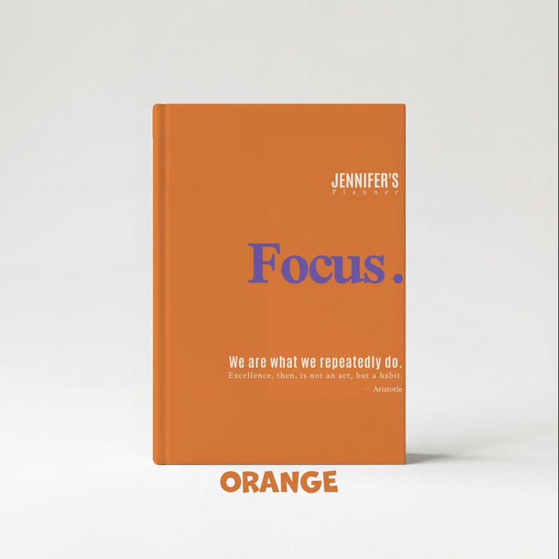 May include: An orange planner with the text "Focus" in blue. The planner also includes the text "JENNIFER'S planner", a quote by Aristotle, and the word "ORANGE".
