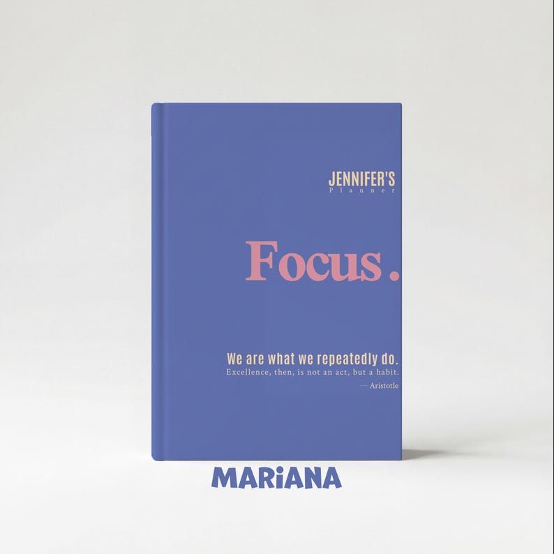 May include: A blue planner with the text "JENNIFER'S PLANNER" at the top. The word "Focus" is in large pink letters. Below, it reads "We are what we repeatedly do." and "MARIANA" at the bottom.