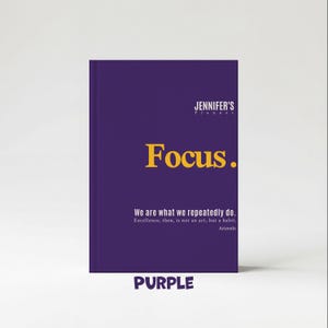 May include: A purple planner with the text "JENNIFER'S Planner" at the top. The word "Focus" is in large yellow letters. Below, it reads "We are what we repeatedly do." and "PURPLE" at the bottom.