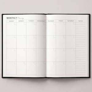 May include: Open black notebook with a monthly planning layout. The left page displays a calendar grid with days of the week across the top. The right page has a notes section. The words "MONTHLY Planning" are at the top.