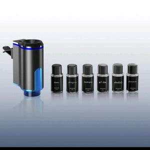 Op de afbeelding: Een zwarte en zilveren auto-luchtverfrisser met blauwe verlichting, naast zes kleine zwarte flesjes diffuserolie. De flesjes zijn gelabeld met "Ocean", "Singing", "Ambergris", "W-ton", "dimlight" en "Encounter".