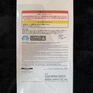 May include: White product box with Japanese text and warnings. The box features Japanese characters, warnings about small parts, and the BANDAI SPIRITS CO., LTD. logo. The box is on a dark surface.