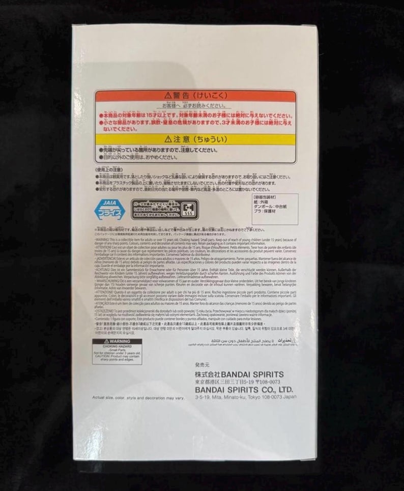May include: White product box with Japanese text and warnings. The box features Japanese characters, warnings about small parts, and the BANDAI SPIRITS CO., LTD. logo. The box is on a dark surface.