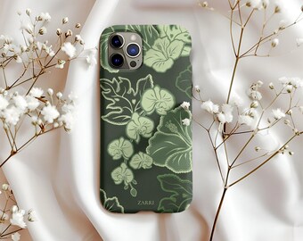 May include: A dark green phone case with a floral design in shades of green. The case features a pattern of leaves and flowers, with the brand name "ZARRI" printed at the bottom. The case is displayed on a white satin surface with white flowers.