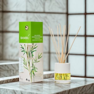 Può includere: Un diffusore di oli essenziali in vetro bianco e trasparente con bastoncini di legno. Il diffusore è accanto a una scatola con la scritta "BAMBU" e un'illustrazione di bambù. La scatola ha toni verdi e beige.