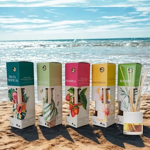 Puede incluir: Cinco cajas rectangulares de cartón para difusores de varillas, cada una con ilustraciones botánicas y etiquetas Fruta Tropical, Pistachio, Frambuesa, Magnolia y Bambu, junto a un frasco difusor de vidrio con varillas de madera.