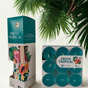 May include: Two boxes of tropical-themed home fragrance products. One box contains a diffuser with reeds and a tropical fruit and flower design. The other box holds teal tealight candles. Both boxes have the words "FRUTA TROPICAL" printed on them.