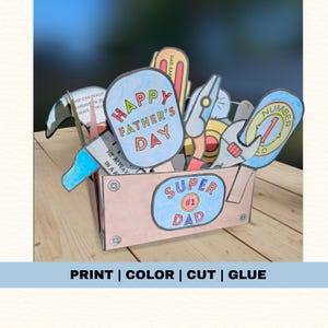 Puede incluir: Una caja de regalo del Día del Padre hecha a mano con herramientas y mensajes de papel de colores. La caja presenta un óvalo azul con "SUPER #1 DAD" y un letrero que dice "HAPPY FATHER'S DAY". La imagen también incluye el texto "PRINT | COLOR | CUT | GLUE".