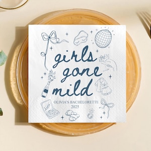 May include: White paper napkin with blue illustrations and text. The text reads "girls gone mild" with additional text "Olivia's Bachelorette 2025". The napkin features drawings of a disco ball, champagne bottle, and pajamas.