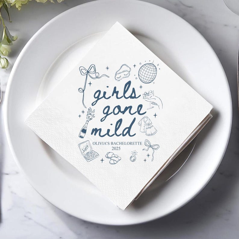May include: White square paper napkin with blue illustrations and text. The text reads "girls gone mild" with additional drawings of a disco ball, champagne bottle, and other party-themed icons. The text "Olivia's Bachelorette 2025" is also included.
