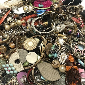 May include: A large collection of assorted earrings in various colors, shapes, and materials. The earrings are made of metal, plastic, wood, and other materials. Some of the earrings are decorated with beads, stones, and other embellishments.