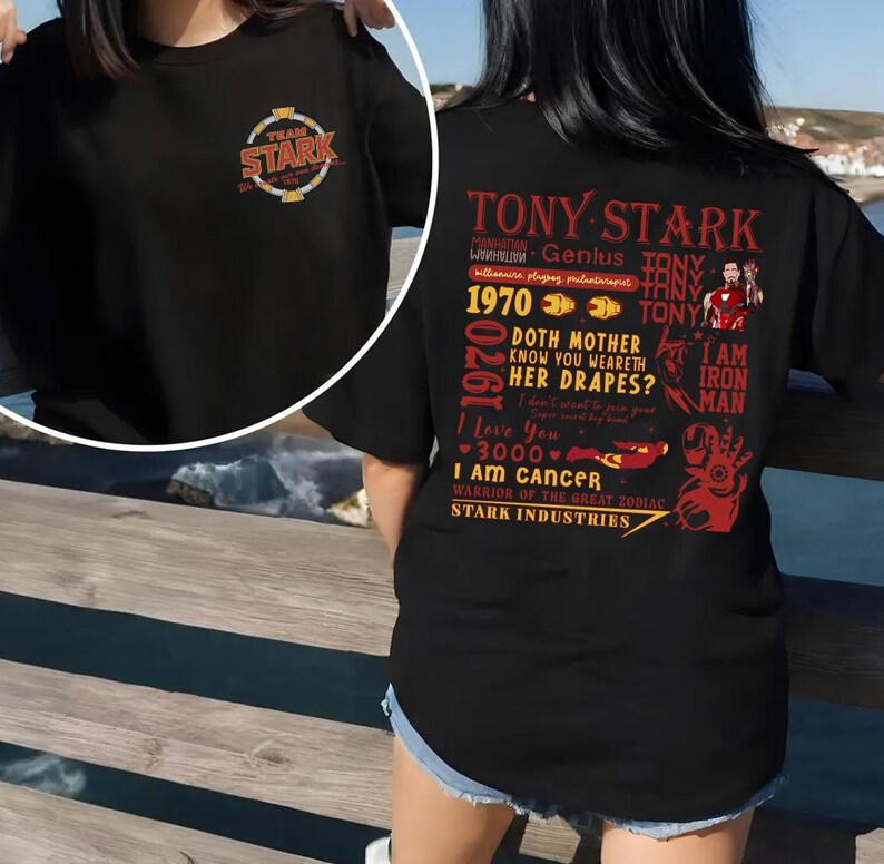 May include: Black t-shirt featuring the text "TEAM STARK" on the front and a graphic of Tony Stark with various quotes and phrases on the back. The design includes the words "TONY STARK", "I AM IRON MAN", and "STARK INDUSTRIES".