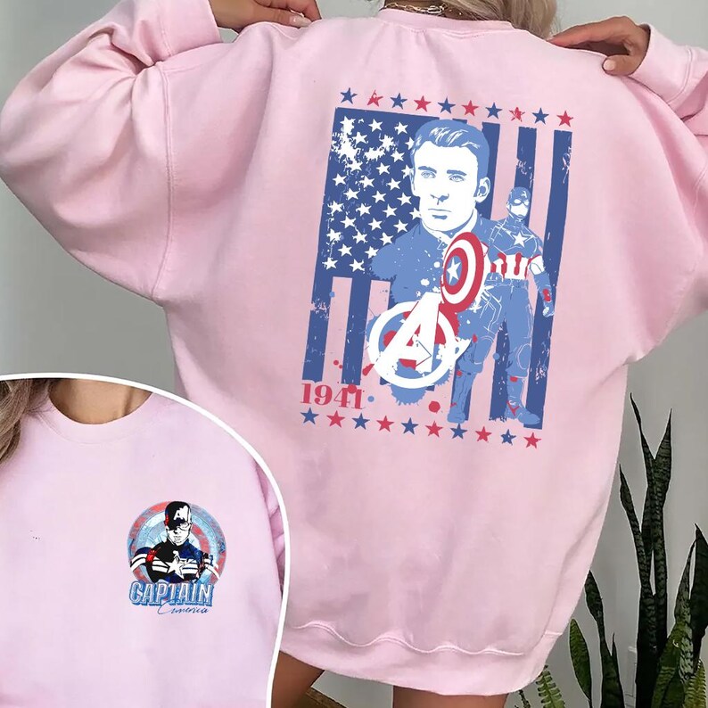 May include: Light pink sweatshirt featuring a graphic of Captain America with the American flag and the text "1941." A smaller graphic of Captain America is on the front. The sweatshirt is a casual garment.