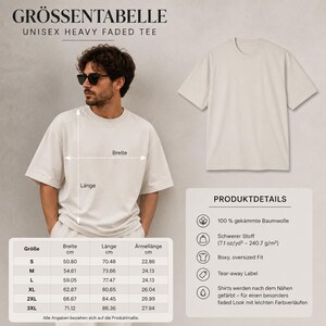 May include: A beige unisex heavy faded t-shirt with a boxy, oversized fit. The image includes a size chart with measurements in centimeters for sizes S through 3XL, and product details listing 100% combed cotton and a weight of 7.1 oz/yd2.