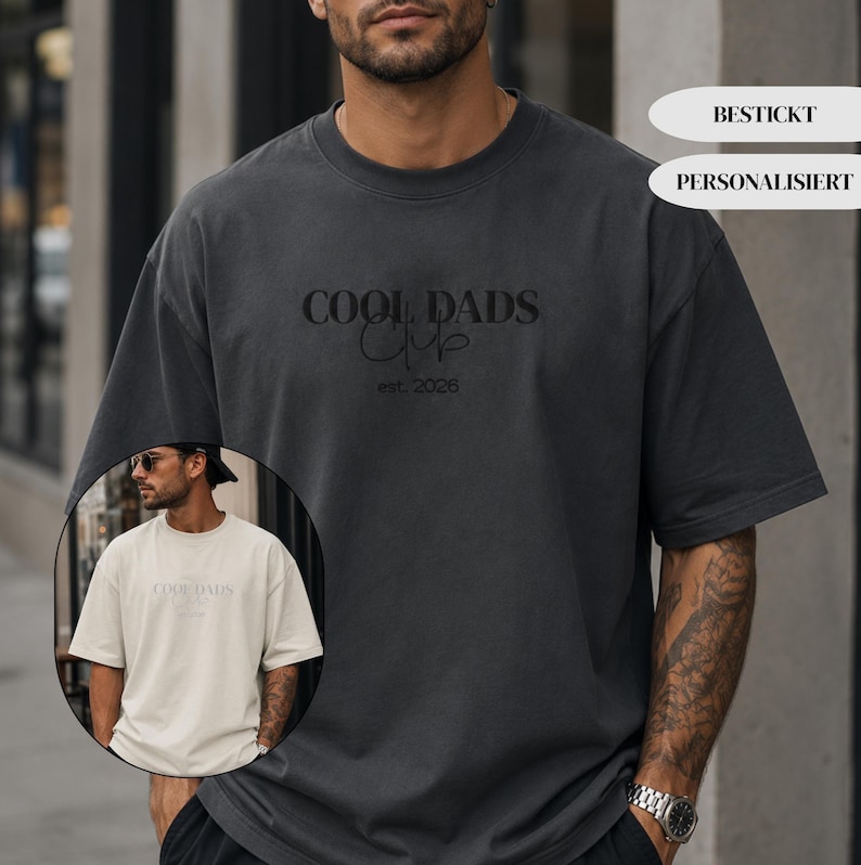 May include: A charcoal gray short-sleeved t-shirt featuring the embroidered text COOL DADS CLUB and est. 2026 in black thread. A circular inset shows the same t-shirt design in a light beige color. The shirt has a crew neckline and loose fit.