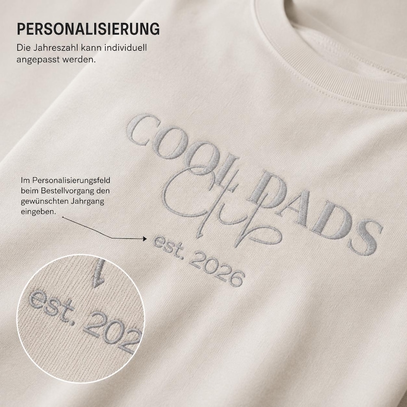 May include: A beige sweatshirt featuring the embroidered text COOL DADS CLUB and est. 2026 in a grey thread. The image includes German text regarding personalization options, with a circular inset showing a close-up of the embroidered year detail.