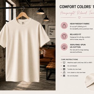 Pu&ograve; includere: Una t-shirt a maniche corte color crema appesa a una gruccia di legno. L'immagine include testo che dettaglia le specifiche Comfort Colors 1717: tessuto pesante da 206,8 g/m2, vestibilit&agrave; rilassata, 100% cotone americano e istruzioni di lavaggio.