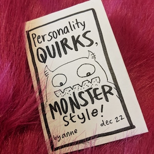 May include: A black and white illustration of a monster with the text "Personality Quirks, Monster Style!" and "by anne" below the monster. The text "dec 22" is in the bottom right corner.