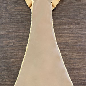 Op de afbeelding: Een beige gewatteerd vest met een nep bont randje rond de randen en banden. Het vest heeft een Y-vormige rug.