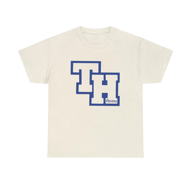 Peut inclure: T-shirt cr&egrave;me avec un motif de lettres bleues "TH" et le mot "Ravens" en dessous. Le t-shirt est fait d'une mati&egrave;re douce et a un col rond. Un v&ecirc;tement d&eacute;contract&eacute; et confortable.