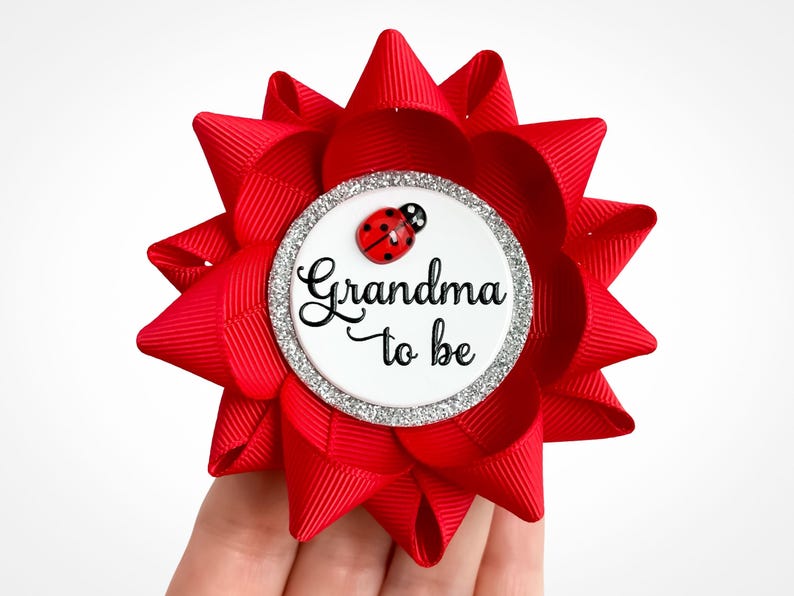 Ladybug baby shower pin made of red ribbon with red ladybug decoration and custom text: Grandma to be