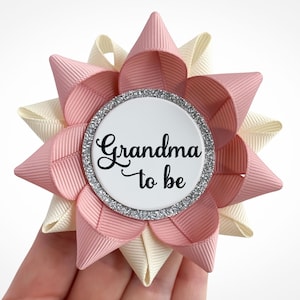 Baby shower corsage pin made of blush and ivory ribbon with silver accent and custom text: Grandma to be