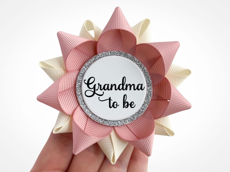 Baby shower corsage pin made of blush and ivory ribbon with silver accent and custom text: Grandma to be