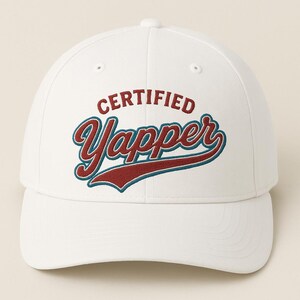 May include: White baseball cap with the text "CERTIFIED Yapper" in red and teal lettering. The cap has a curved brim and a classic six-panel design. A stylish accessory for casual wear.