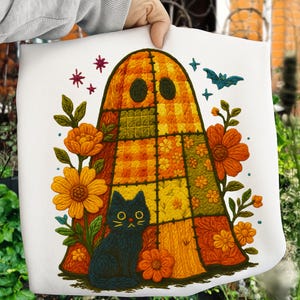 May include: White tote bag featuring a patchwork ghost design in shades of orange, yellow, and green. A black cat sits below the ghost, surrounded by orange flowers, stars, and a blue bat. The design has a vintage, Halloween theme.