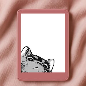 Op de afbeelding: Een roze e-reader toont een zwart-wit illustratie van een kat die over de bovenkant kijkt. De ogen van de kat zijn wijd met een verraste uitdrukking. De e-reader staat tegen een roze stoffen achtergrond.