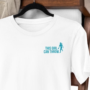 This Girl Can Throw-skjorta | Gildan 64000 | Damtröja med kornhålmotiv | Modern kornhålslogotyp på bröstet