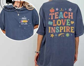 May include: A navy blue t-shirt with the words "TEACH LOVE INSPIRE" in colorful letters on the back. The front of the shirt has a pencil graphic and the text "Mrs. Smith 1st Grade".