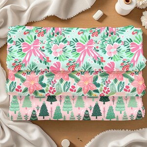 May include: Three folded fabric pieces with festive patterns. The top fabric has a mint green background with pink bows and floral designs. The middle fabric features pink poinsettias and greenery. The bottom fabric has a pink background with green Christmas trees.
