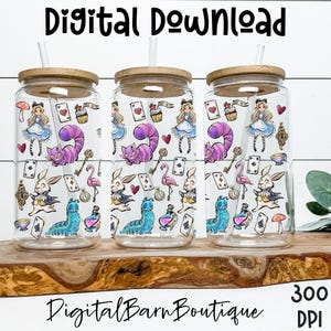 Op de afbeelding: Drie glazen bekers met bamboe deksels en rietjes, versierd met illustraties met het thema Alice in Wonderland. De ontwerpen omvatten Alice, de Cheshire Cat, speelkaarten en andere iconische afbeeldingen. De bekers worden gepresenteerd op een houten oppervlak.