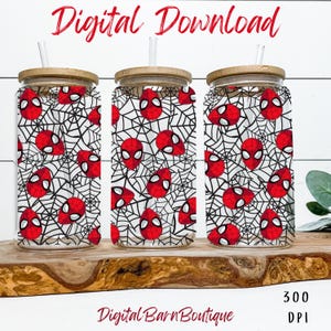 Puede incluir: Tres vasos de vidrio con tapas de bambú y pajitas. Cada vaso presenta un diseño de máscara de Spider-Man roja sobre un fondo de telaraña blanca. Las palabras "Digital Download" están en escritura roja en la parte superior y "Digital Barn Boutique" en la parte inferior.