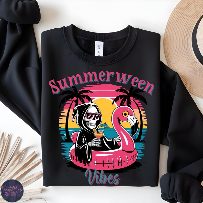 May include: Black crewneck sweatshirt with a graphic featuring a Grim Reaper in sunglasses, holding a cocktail while floating on a pink flamingo pool float. The text "Summerween Vibes" is displayed in pink and teal.