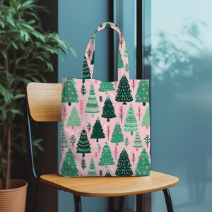 May include: A pink tote bag with a repeating pattern of green Christmas trees and red heart accents. The trees are of various styles and sizes, set against a light pink background. The bag has matching handles.