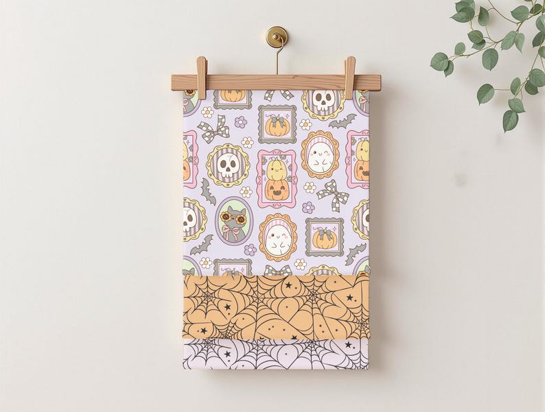 May include: A Halloween-themed fabric panel featuring a repeating pattern of framed skulls, pumpkins, ghosts, and cats in pastel colors. Below, layers of fabric display spiderwebs in orange and white, perfect for seasonal crafts.