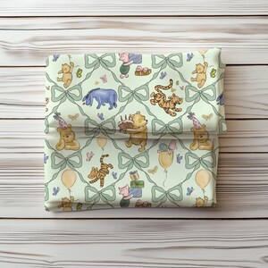 May include: A folded fabric item featuring a repeating pattern of Winnie the Pooh characters, bows, and butterflies on a light green background. The characters include Pooh Bear, Tigger, Piglet, and Eeyore, with birthday party elements.