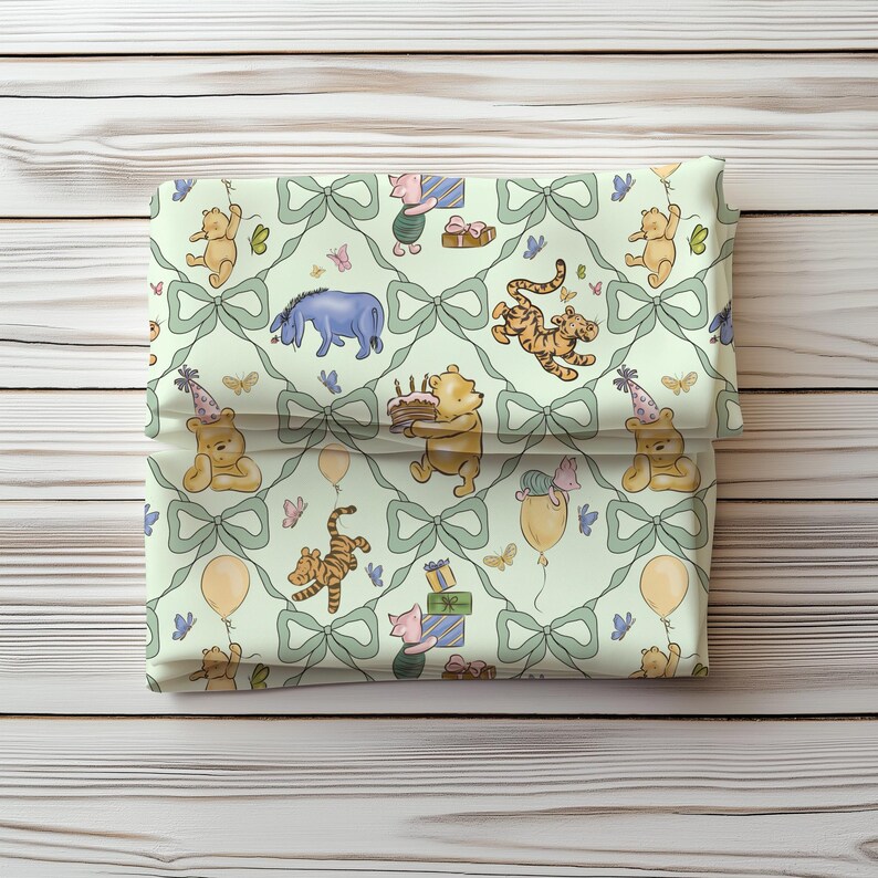 May include: A folded fabric item featuring a repeating pattern of Winnie the Pooh characters, bows, and butterflies on a light green background. The characters include Pooh Bear, Tigger, Piglet, and Eeyore, with birthday party elements.
