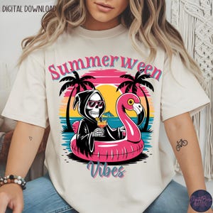May include: Cream-colored t-shirt with a graphic featuring a skeleton in a black hooded robe and sunglasses, holding a cocktail while floating on a pink flamingo pool float. The text "Summerween Vibes" is displayed above and below the graphic, with palm trees and a sunset background.