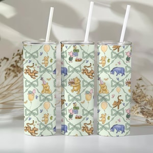 May include: Three insulated tumblers with white straws. The tumblers feature a repeating pattern of Winnie the Pooh characters, balloons, and gifts on a light green background with bows. The design includes Pooh Bear, Piglet, Tigger, and Eeyore.