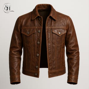 Può includere: Giacca in pelle marrone dal design classico. La giacca presenta un colletto, due tasche sul petto e chiusure con bottoni. La pelle ha un aspetto invecchiato, che le conferisce un look vintage. La giacca è di colore marrone medio.