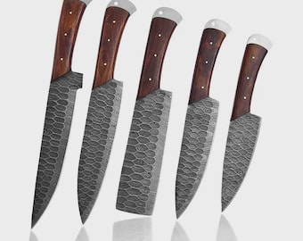May include: Set of five kitchen knives with dark wood handles and textured gray blades. The handles have a curved design with a silver bolster. The blades have a unique pattern. The knives are arranged on a light gray background.