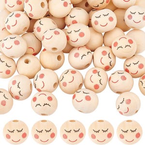 May include: A collection of light wooden beads, each adorned with a painted smiling face. The faces feature closed eyes, rosy cheeks, and a curved red mouth. The beads are round and have a hole for stringing.