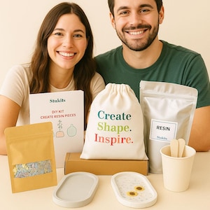 May include: A DIY resin kit with a variety of supplies, including resin, molds, and a drawstring bag with the words "Create. Shape. Inspire." printed on it. The kit also includes a booklet and a small cup with wooden stirrers.