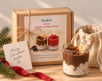 May include: A DIY candle making kit in a brown cardboard box labeled Stukits, featuring a photo of two candles, a small beige drawstring bag, a lit chocolate-scented candle in a glass, and a card with the text Merry Christmas bestie.