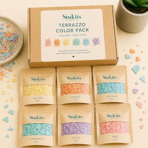 May include: A Stukits Terrazzo Color Pack box containing six 50g pouches of decorative chips in yellow, orange, sky blue, turquoise, violet, and pink. The box label reads Terrazzo Color Pack, 6 Colors, 300gr Total, and Decorative chips for Jesmonite.