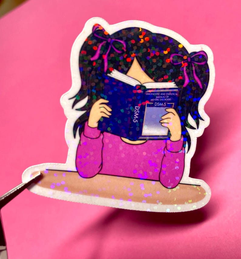 Girl reading and studying DSM-5 sticker featuring a cute girl wearing pink with bows in her black hair, psychology humor sticker for grad students and therapists