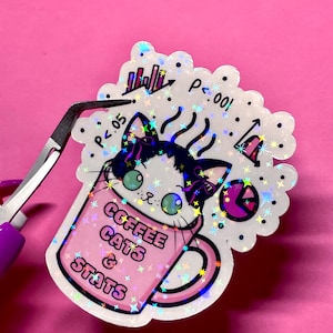 May include: A holographic sticker featuring a cat in a pink coffee mug with the words "Coffee Cats & Stats." The sticker has a white border with statistical symbols and the text "P<.05" and "P<.001."